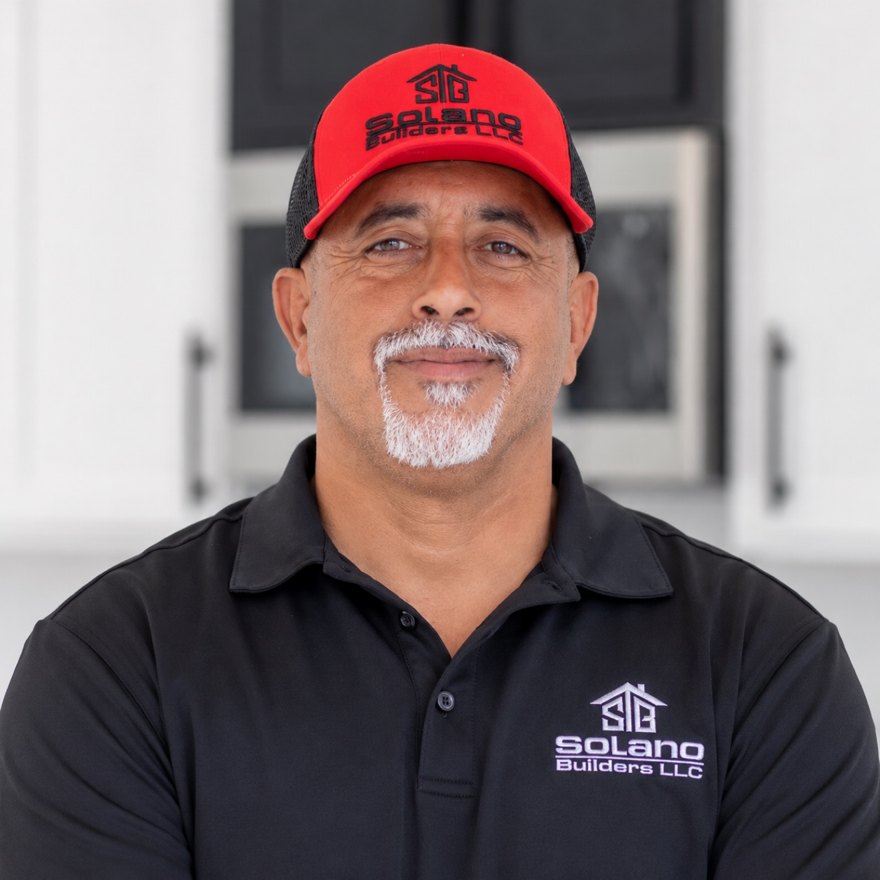 Jose Solano, Founder of Solano Builders and Construction, wearing a Solano Builders polo and red cap